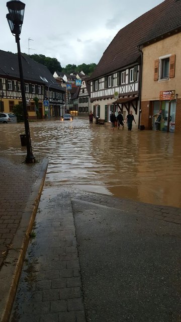 Anwohner waten durch das knietief stehende Wasser in der Steiner Ortsmitte. | Foto: privat