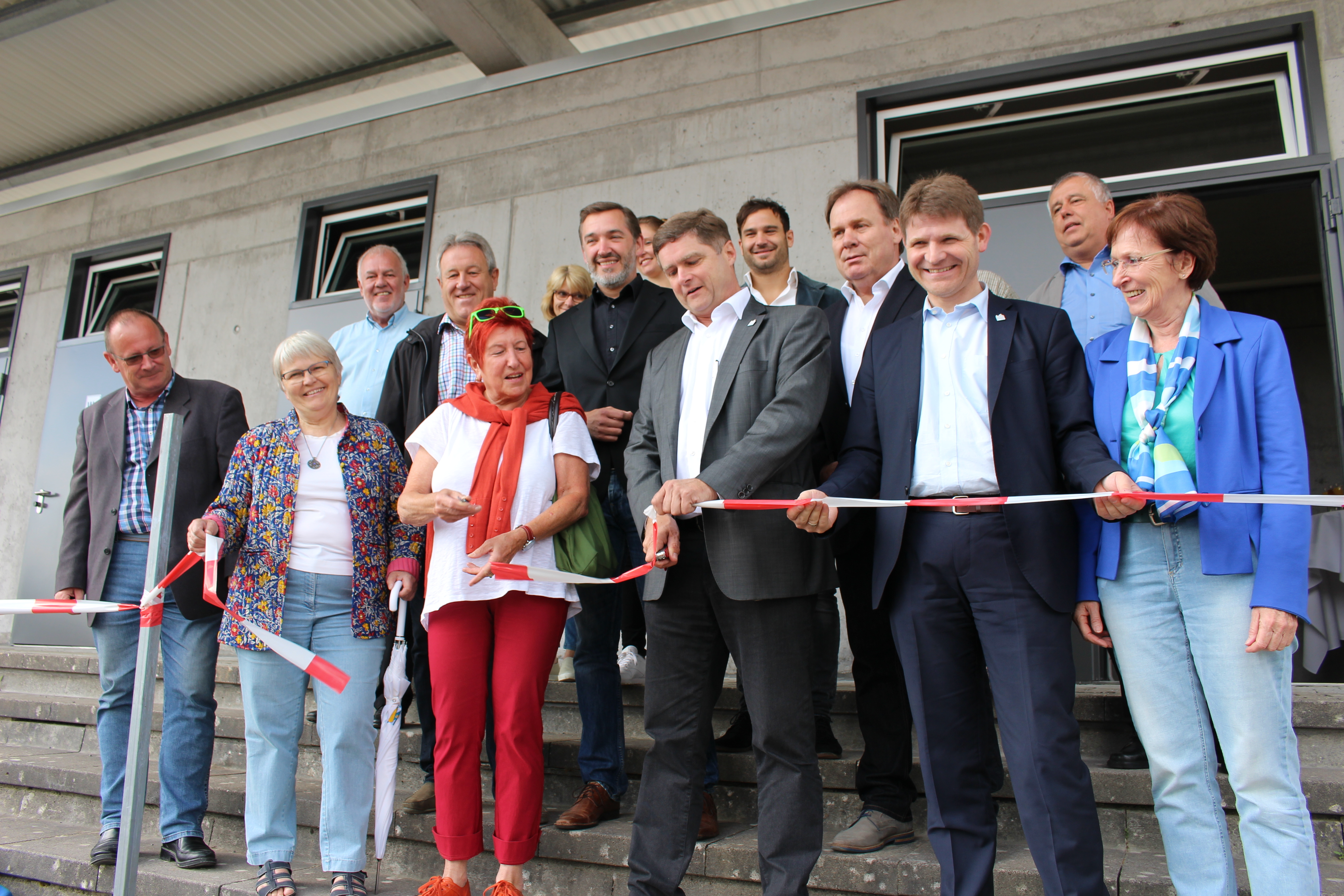 Das Baustellenabsperrband schnitten symbolisch durch: (erste Reihe von links) Gemeinderäte Bernd Diernberger, Heidemarie Leins, Renate Knauss, Oberbürgermeister Martin Wolff, Bügermeister Michael Nöltner, Annelie Richter, Rektorin des Edith-Stein-Gymnasium, Amtsleiter Ulricht Hipp (Zweite Reihe, Erster von links),Architekt Markus Weiss (daneben), Martin Knecht, Rektor der Max-Planck-Realschule (Zweite Reihe, Erster von rechts), Amtsleiter Walter Gruper (hinten links) und Amtsleiter Bernhard Feineisen(rechts