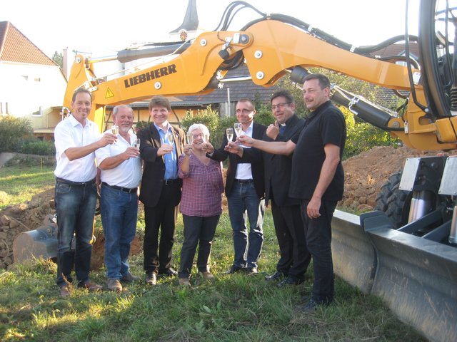 Stoßen auf den Baubeginn an (von links): Pfarrgemeinderat Rüdiger Kampa, Ortsvorsteher Rolf Wittmann, Bürgermeister Michael Nöltner, Pfarrgemeinderätin Beate Bachmann, Architekt Stefan Nessler, Pfarrer Harald-Mathias Maiba, Pfarrer Wolfgang Streicher.
