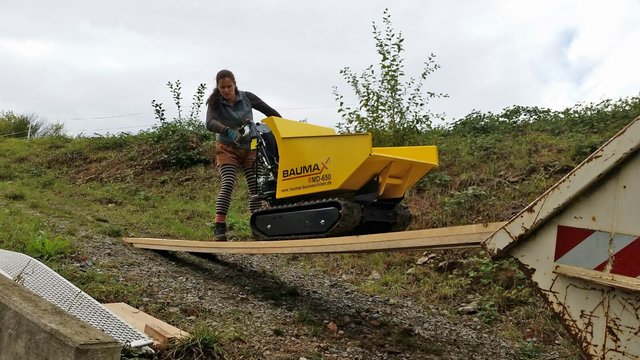 Antje Bohnstedt schafft mit einem Dumper Erde und Geröll weg.