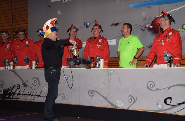 Er hat ein mit Luftschlangen geschmücktes Fläschchen mitgebracht ...