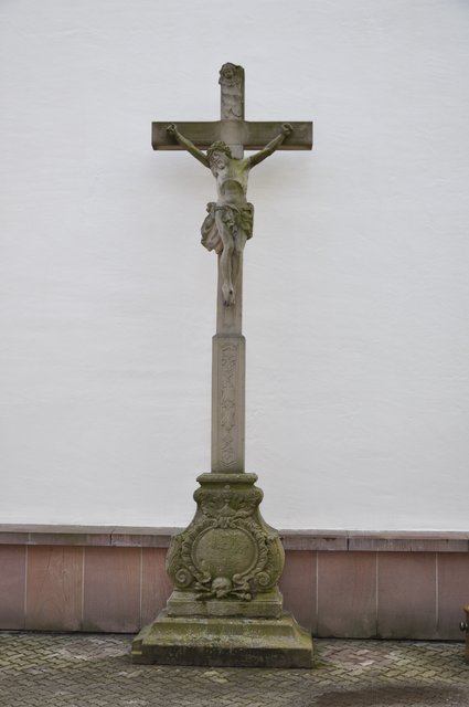 Steinernes Kruzifix am Kirchplatz an der Nordseite der Kirche. Foto: ch