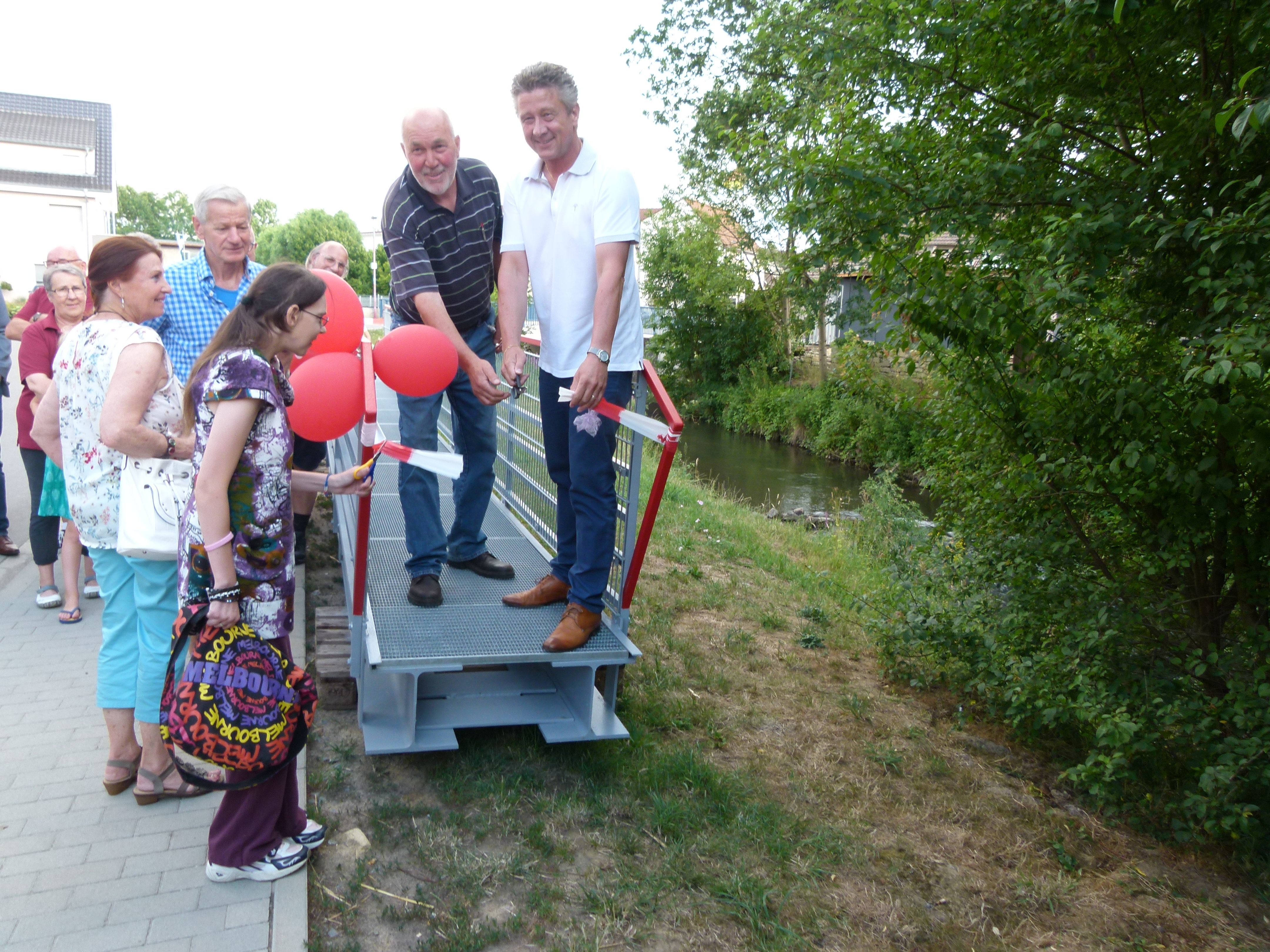 Symbolischer Scherenschnitt von Gerhard Scheck (links) und Bürgermeister Ulrich Hintermayer: Die Brücke ist fertig