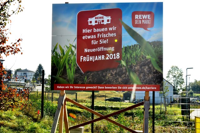 22. September: Das aufgestellte Schild verkündet die Neueröffnung des REWE-Lebensmittelmarkts im Frühjahr 2018.