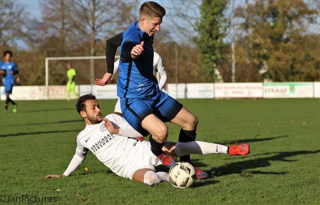 Adnan Bayrak von den Kickers Büchig am Boden gegen Florian Hammes in blau vom VfB Bretten