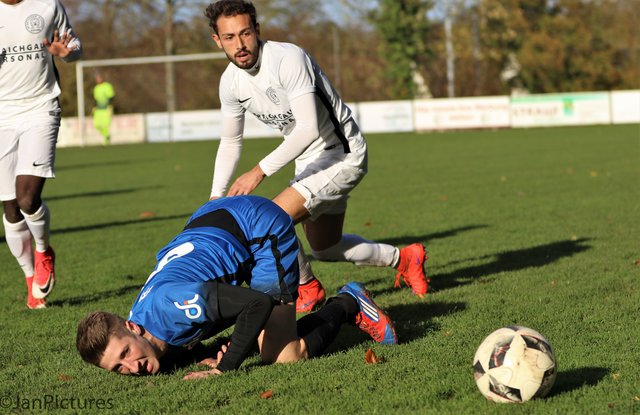 Adnan Bayrak von den Kickers Büchig am stehend gegen Florian Hammes in blau vom VfB Bretten