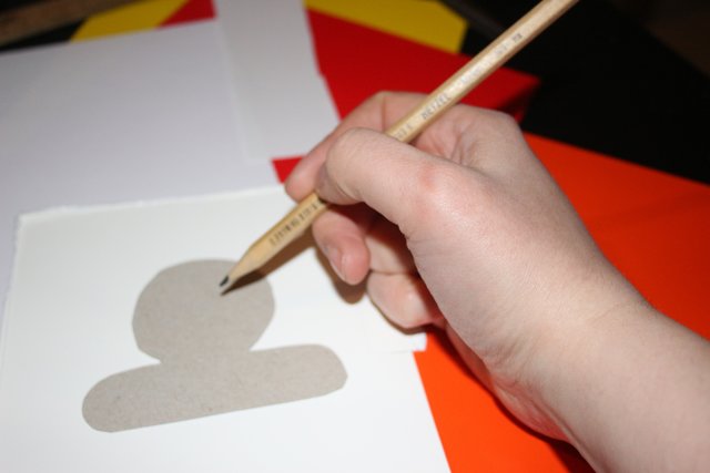 Wichtig ist eine Schablone für den Körper, die den Kopf und die Arme der Figur darstellt. Die Schablonen auf festem Tonpapier aufzeichnen und ausschneiden.