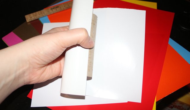 Das Buntpapier schön eng um die Papprolle wickeln, sodass sich keine Falten oder Blasen bilden.