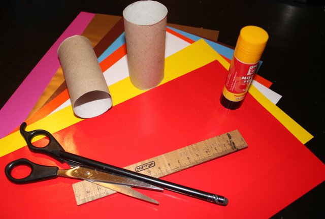Das braucht ihr: Toilettenpapier-Rollen, Bunt- und Tonpapier, Klebstoff, ein Lineal und ein Bleistift und eine Schere.