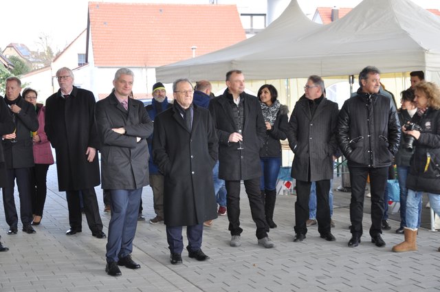 Bei sonnigem, aber kaltem und mitunter recht windigem Wetter versammelten sich die Gäste am rückwärtigen Eingang. Foto: ch