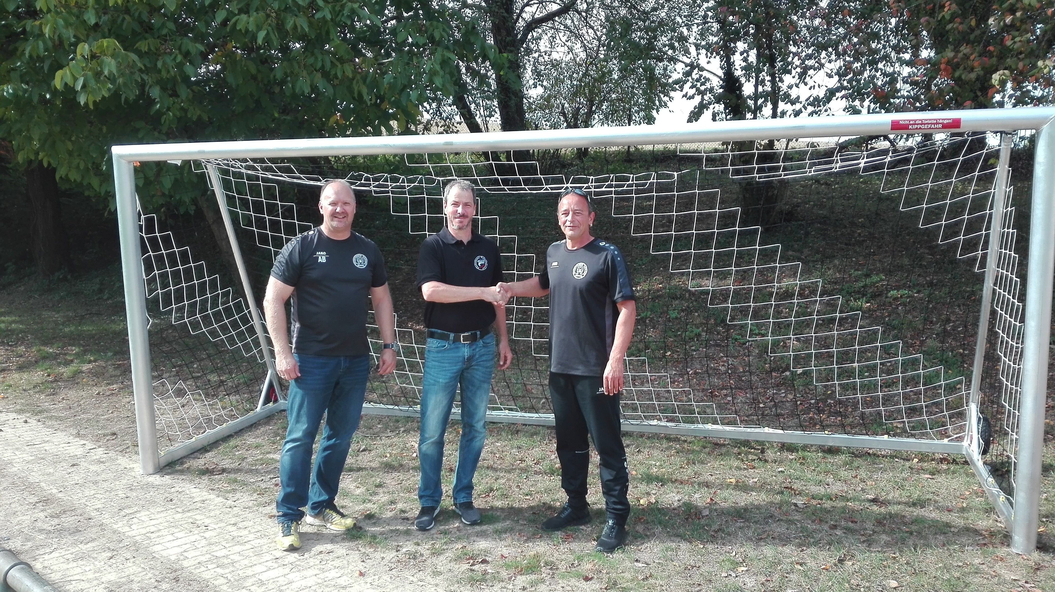 Der erste Vorsitzende Matthias Koch (Mitte) und der zweite Vorsitzende Axel Braust (links) vom Förderkreis Fußballjugend übergaben dem Jugendleiter des SV Kickers Büchig Bernd Bachmann vier neue Tore für den Jugendfußball.