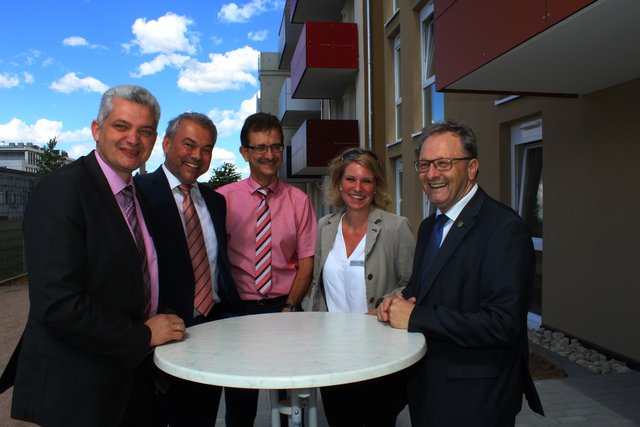 Kooperation mit dem Landkreis bei der Flüchtlingsunterbringung: (von rechts) Bürgermeister Thomas Nowitzki, die Amtsleiterin für Gebäudemanagement im Landratsamt Barbara Früh, Sozialdezernent Peter Kappes, Kommunalbau-Geschäftsführer Dieter Motzer und Finanzdezernent Ragnar Watteroth bei der Einweihung des bislang größten Kommunalbau-Projekts, des 2017 fertiggestellten Mehrfamilienhauses mit 33 Wohnungen in der Flehinger Straße 37. | Foto: Kommunalbau GmbH