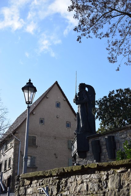 Blick vom tiefer gelegenen Rathausplatz auf die Statue am Kirchhof. Foto: ch