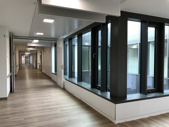 Wahlleistungsstation: Gang mit Fußboden in Holzdielenoptik. | Foto: Arcass Planungsgesellschaft