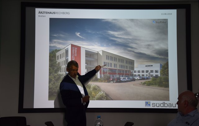 Südbau-Geschäftsführer Markus Vierling erläutert am ursprünglichen Planentwurf, warum das rote Bestandsgebäude (Mitte) nicht um zwei, sondern nur um ein Geschoss aufgestockt werden kann. | Foto: ch