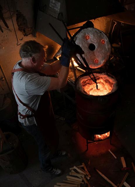 Vorsicht geboten: Mit einer langen Zange entnimmt Tom Naumann die Tonfigur aus dem 1.000 Grad heißen Holzofen. | Foto: privat