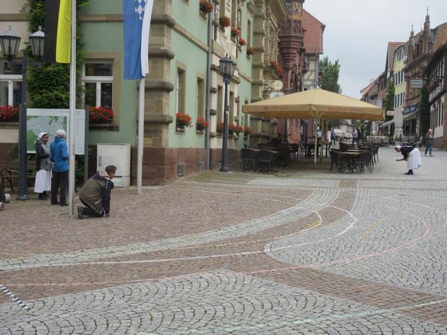 Am Tag vor Fronleichnam zeichnete Pfarrer Harald-Mathias Maiba mit tatkräftiger Hilfe die Felder für die Familien auf dem Marktplatz auf. | Foto: ger