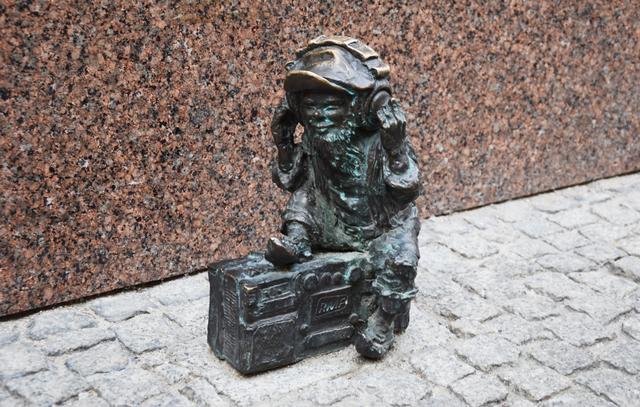 Musikhören auf der Straße: Zwerg mit Ghettobluster auf dem Pflaster vor einer Hauswand in Wroclaw. | Foto: ch