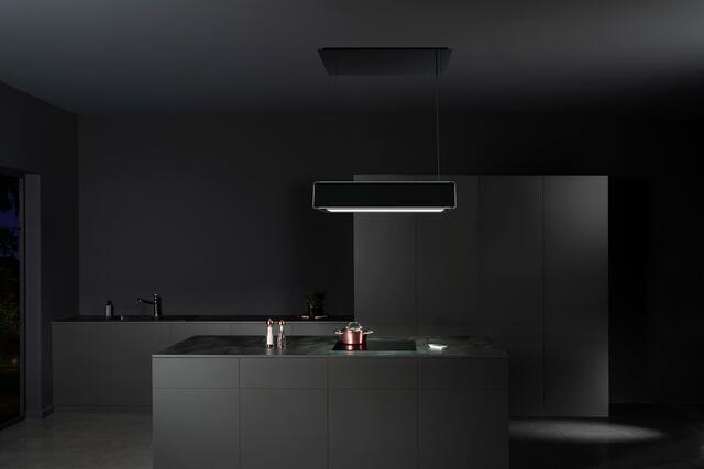 Diese höhenverstellbare Deckenlifthaube verbindet zeitgenössisches Design mit smarter Technik und erzeugt mit ihrer Ambiente- und Effektbeleuchtung eine einzigartige Lichtstimmung. Sie ist für die Gerätevernetzung vorbereitet und kann bequem per Mobile/App gesteuert werden.  | Foto: AMK