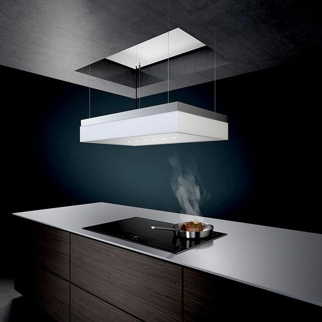 Prämiertes Premium-Ensemble: Der Design-Deckenlüfter mit individueller Höhenverstellbarkeit lässt sich mittels Fernbedienung, App- oder Sprache steuern und ermöglicht freie Sicht vor und nach dem Kochvorgang. Dazu ein smartes Vollflächen-Induktionskochfeld ohne vordefinierte Kochzonen.  | Foto: AMK