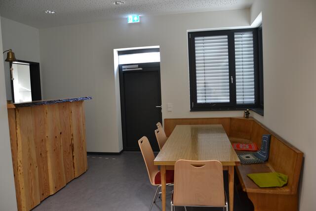 Ihre altgediente Eckbank wollten die Feuerwehrleute unbedingt auch im neuen Feuerwehrhaus haben. Links die selbst erstellte Bar, dahinter schließt sich die Küche an.  | Foto: ger