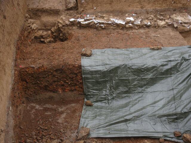 Viele Tonscherben und Kohlereste legen die Vermutung nahe, dass hier ein abgebranntes Dach liegt. 