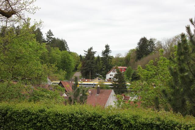 Blick auf eine vorbeifahrende Stadtbahn. Auf dem Kirchplatz ist diese deutlich lauter zu hören, als im Anwohnergarten. | Foto: bea