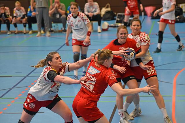 Cara Reuthal (26/RR) tankt sich in der dramatischen zweiten Hälfte halbrechts durch und erzielt in 51.Minute das 20:22. Aleksandra Dorsz (Nr.7) versucht sie noch per Trikottest zu stoppen, was aber nicht gelingt. Sina Michels (Nr.3) blockt am Kreis Annika Hermenau (Nr.55).
FotoArchiv Merkel+Merkel