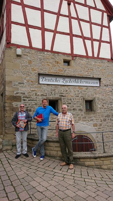 Die Stadtpaten Ottmar Mannherz und Karl Wilms zusammen mit Moderator Jens Hübschen vom SWR vor dem Ersten Deutschen Zuckerbäckermuseum. | Foto: kn