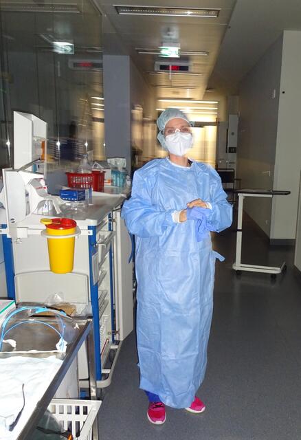 Eine Nachtschwester zieht sich vor der Kontrolle bei einem Coronapatienten Schutzkleidung an. | Foto: Josef Freitag