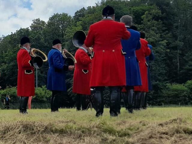 Parforcehornbläser St. Eustachius vor der Waldkulisse. 