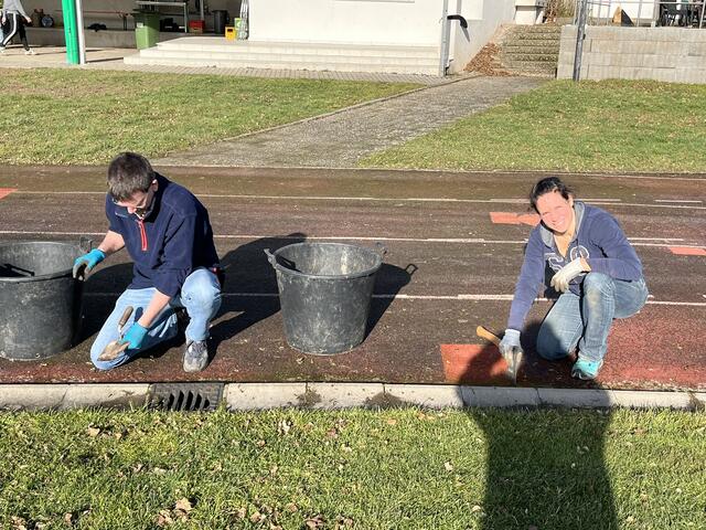 Maica Jegele und Holger Oesseke bei ihrer mühevollen Reinigung der Tartanbahn 