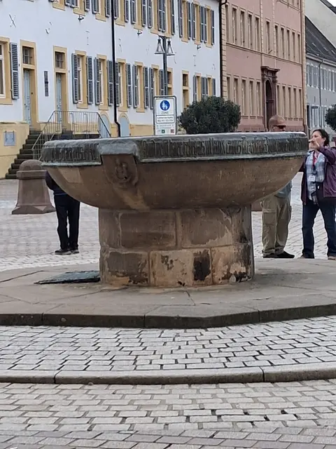 Große Schale aus Sandstein vor dem Kaiserdom. Sie soll gemäß der Überlieferung nach jeder Neuwahl eines Bischofs „für das gesamte Volk“ mit Wein gefüllt werden. Der Napf fasst 1580 Liter und trägt eine lateinische Inschrift. | Foto: A.E. Albert-Berg